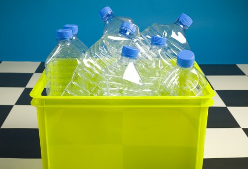 Staff placing food and mixed recycling into labelled bins in a business backroom